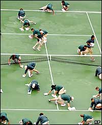 The Flushing Meadows ground crew do all they can to clear away the surface water on court