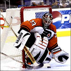 Goaltender Jeff Hackett of the Philadelphia Flyers gets his stick on a shot from Trent Klatt of the LA Kings