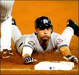 Derek Jeter of the New York Yankees dives safely into third base during their World Series game three win over the Florida Marlins