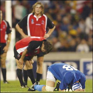 Carlo Checcinato (right) falls to his knees in relief as Italy hold on to beat Canada