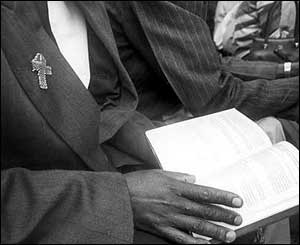 Henry wears a red AIDS ribbon