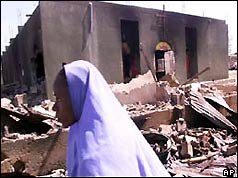 Nigeria woman walks past burnt-out church
