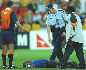 Police attend to a fan who ran onto the pitch
