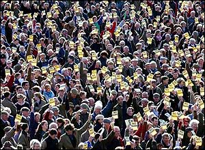 Supporters from many different hunts hold No Ban cards on before they move off from Worcester Lodge, Badminton, Gloucestershire