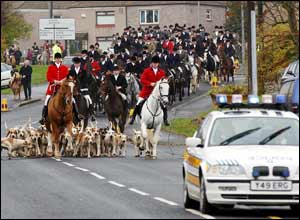Huntsmen and hounds ride past the Trimdon Labour Club, County Durham