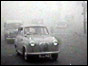 Car driving through fog