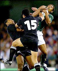 South Africa's Ashwin Willemse of takes the ball in front of Mils Muliaina of New Zealand 