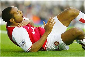 Thierry Henry falls to the ground injured and must receive treatment 