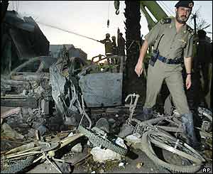 A police officer picks his way through the wreckage 