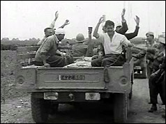 Prisoners wave goodbye from back of a truck