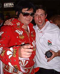A Welsh fan dressed as Elvis jokes with an English fan