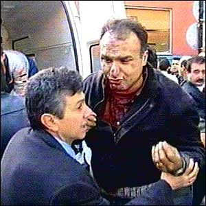 Injured man being helped at scene after bomb blast