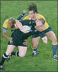 Greg Somerville is tackled by Australian flanker George Smith and scrum-half George Gregan 