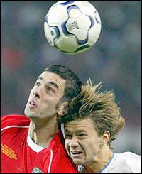 Russia's Dmitry Sichev battles for the ball with Mark Delaney 