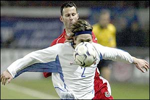 Russia's Vadim Evseev shields the ball from Ryan Giggs