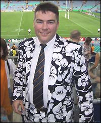 A man in a black-and-white-flowered suit watches the Australia v New Zealand semi-final