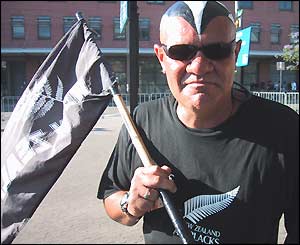 An All Black fans has his face painted and carries a New Zealand flag