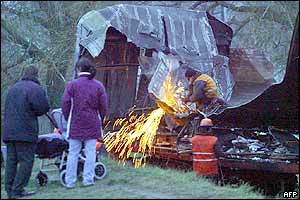 Workers take apart the wreckage of Russian commuter train