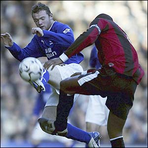 Everton's Wayne Rooney clashes with Man City's Sylvain Distin in a goalless first half