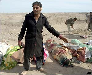 An Iranian man points to the bodies of his family members who were killed in a massive earthquake that hit the ancient Iranian city of Bam 