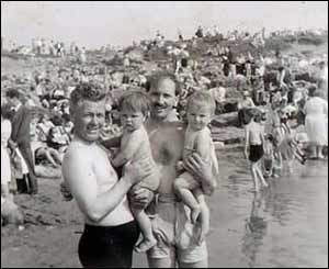 Theodora Simons, originally from Tonyrefail but now lives in France, thinks this was taken at Ogmore-by-sea. She is on the right, in her father's arms. Her uncle is holding her cousin on the left. 