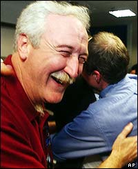 Nasa Administrator Sean O'Keefe hugs a colleague