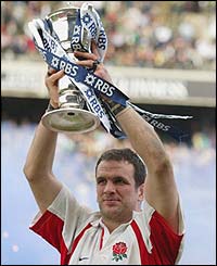 Martin Johnson displays the Six Nations trophy after England claim the Grand Slam