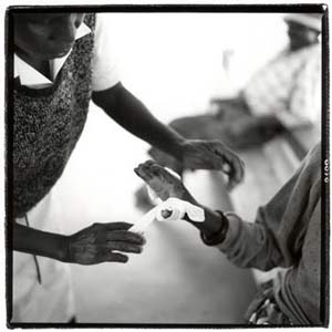 Nurse dressing the wounds of Regina Makumbi at the Mutemwa Leprosy Settlement (Photograph by Simon Roberts)