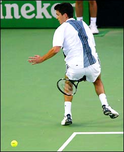 Tim Henman plays a shot through his legs