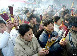 Chinese burn incense sticks for good luck before tossing them into an urn at the White Cloud Temple in Beijing 
