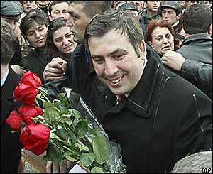 Mikhail Saakashvili carries roses through a crowd outside the Gelati Cathedral