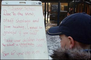 A Schoolboy stands at the entrance of Churchfields junior school in Woodford Green Essex,