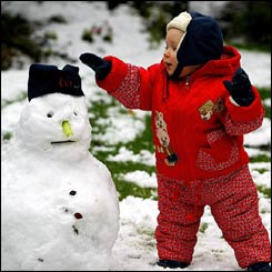 One-year-old Joseph Noble, of Altrincham, Cheshire, puts the finishing touches to his first-ever snowman 
