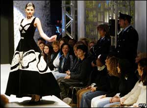 Inmates from Rome's Rebibbia prison watch a model displaying on the catwalk