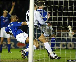 Les Ferdinand sticks out a boot to score Leicester's first goal