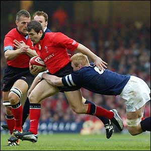 Wales' Iestyn Harris breaks through the tackle of Scotland's Cameron Mather 