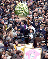 Police and coffin bearers try to get through the massive throng awaiting the funeral