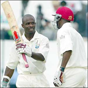 Devon Smith celebrates his century with batting partner Ryan Hinds