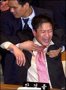 Uri MP Kim Jong-ho pulls distraught comrade Lim Jong-suck aside after the vote