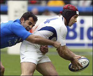 Italian centre Cristian Stoica tackles France wing Vincent Clerc