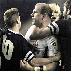 England captain Lawrence Dallaglio is held by back by Scotland players