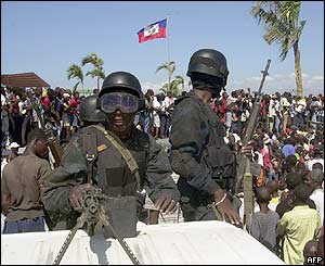 Police watch supporters of Aristide at rally to mark his third anniversary in office, 7 Feb 2004, in Port-au-Prince