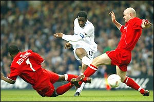 Jay Jay Okocha gets his shot off under pressure from George Boateng and Danny Mills
