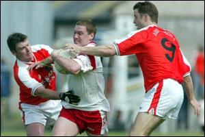 Armagh's Kieran Hughes and Paul McGrane try to hold up Cormac