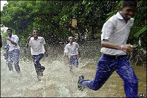 School children run through rainwater in Bombay, India
