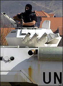 Armed UN police officer watches from tank turret in city of Mitrovica