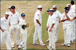 England players await the third umpire's decision 