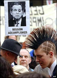 Several men, including one holding a placard of US President George W Bush, stand at Bern protest in Switzerland