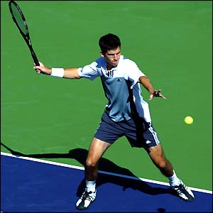 Tim Henman hits a ball to Roger Federer