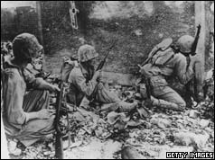 Marines take cover amid wrecked homes and rubble of Okinawa's capital city, Naha